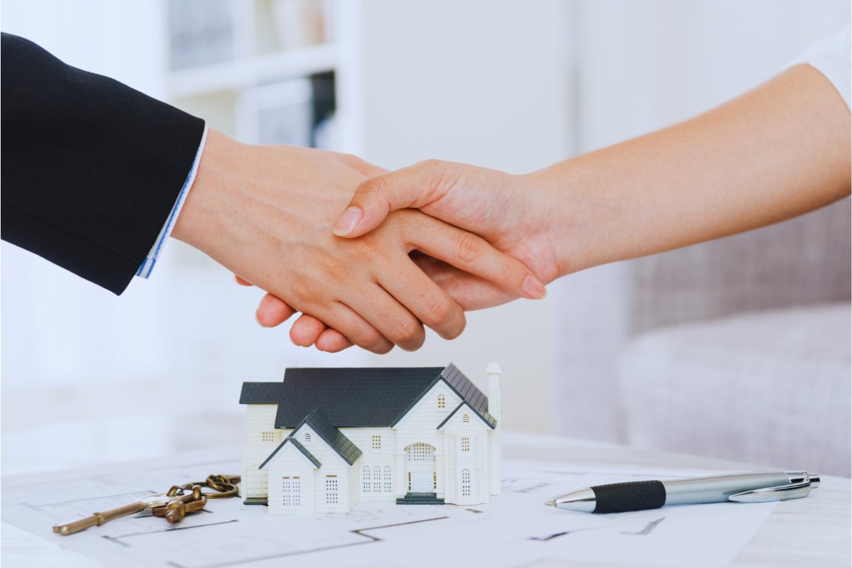 persona compra casa e stringe mano ad agente immobiliare 