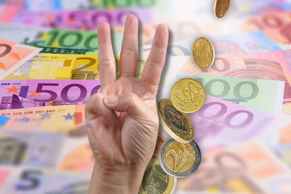 banconote e monete euro con mano che fa 3