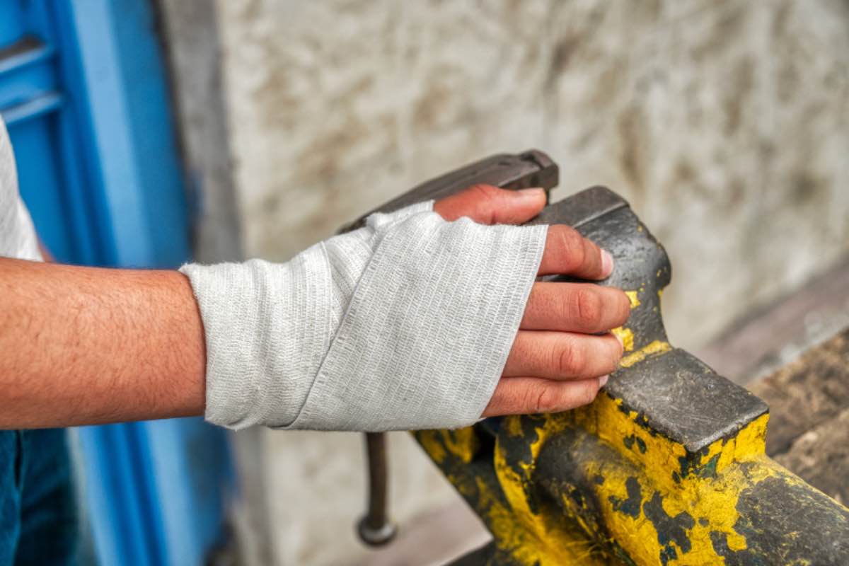 Mano fasciata sul posto di lavoro