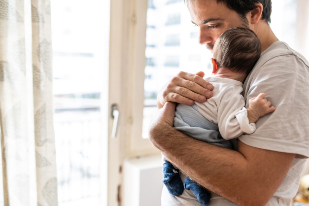 Papà tiene in braccio un neonato