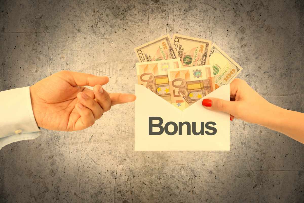 donna consegna a uomo busta bonus con soldi in euro e dollari