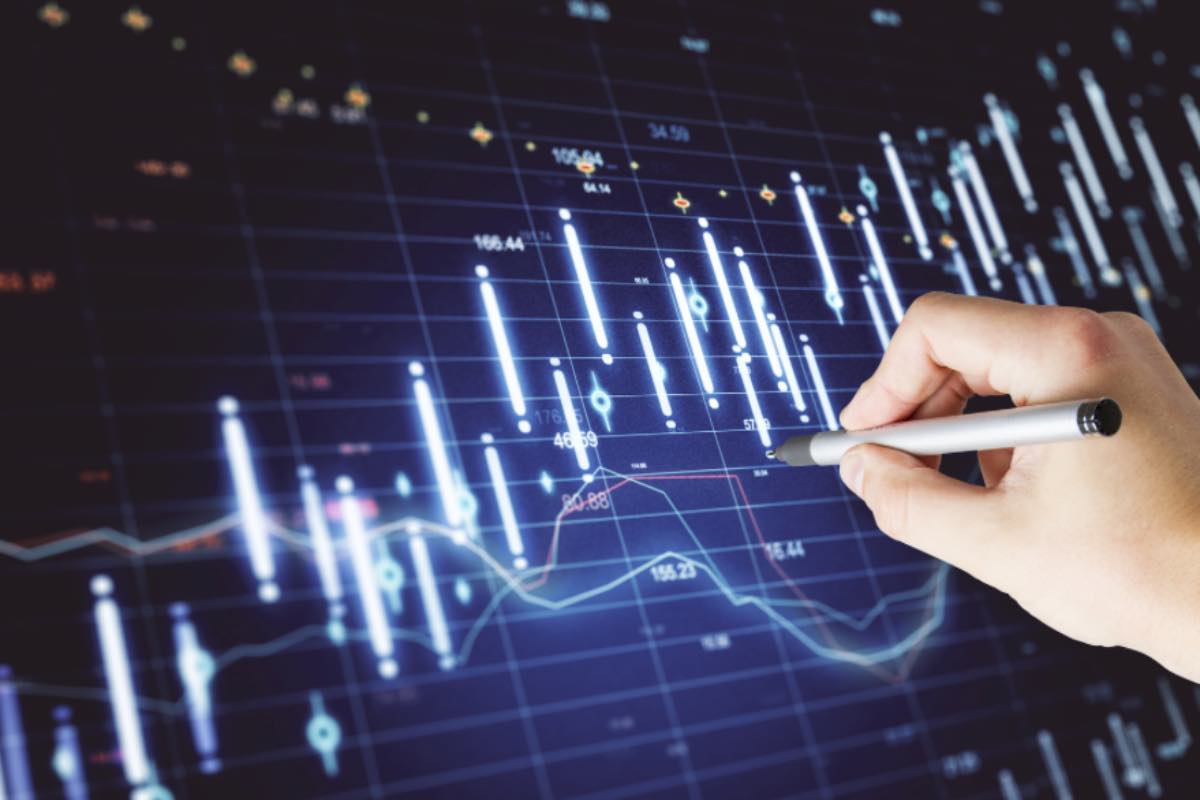 Mano con penna su grafico finanziario 