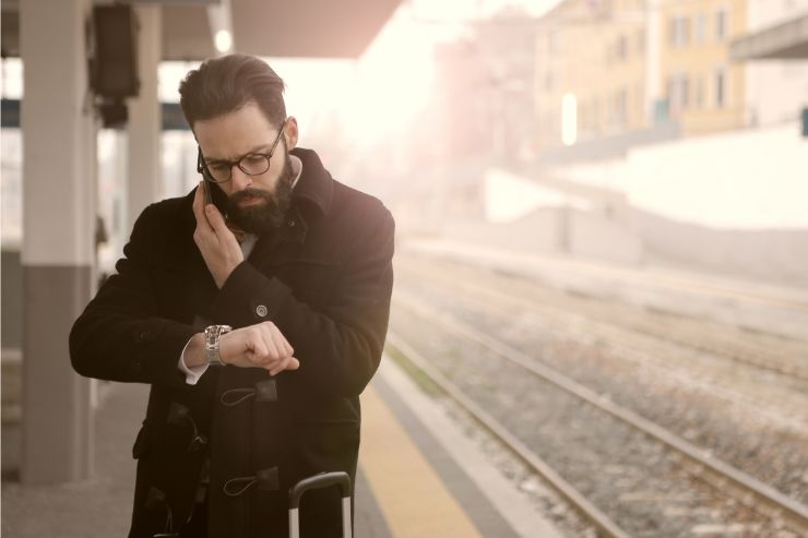 Uomo controlla orario in stazione 