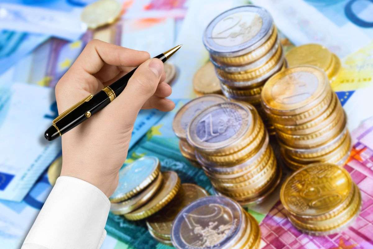 sfondo banconote e monete euro e focus penna in mano