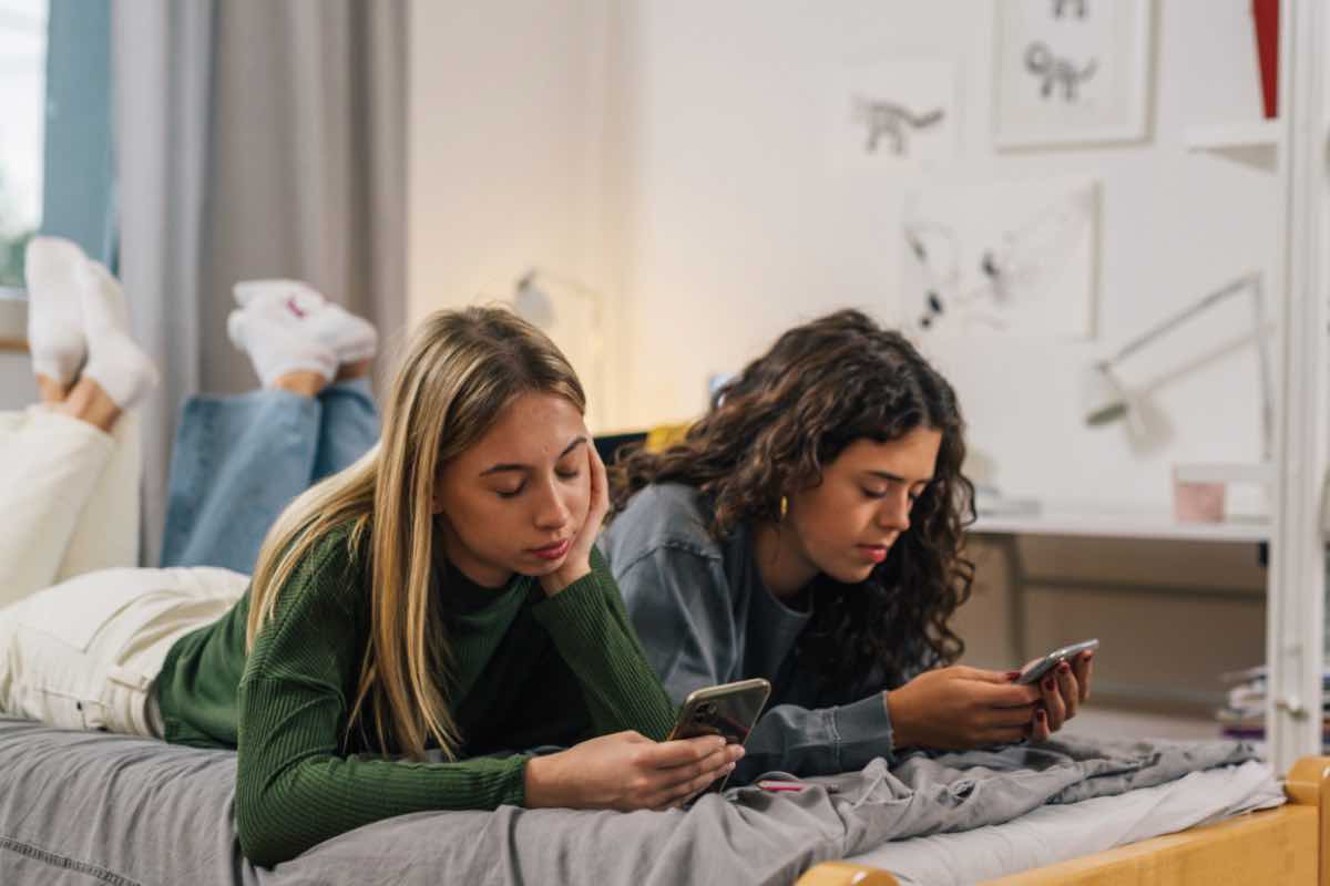 ragazze sul letto con gli smartphone 