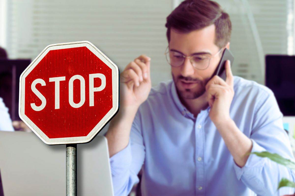 ragazzo ascolta vendite al telefono su sfondo e focus cartello di stop