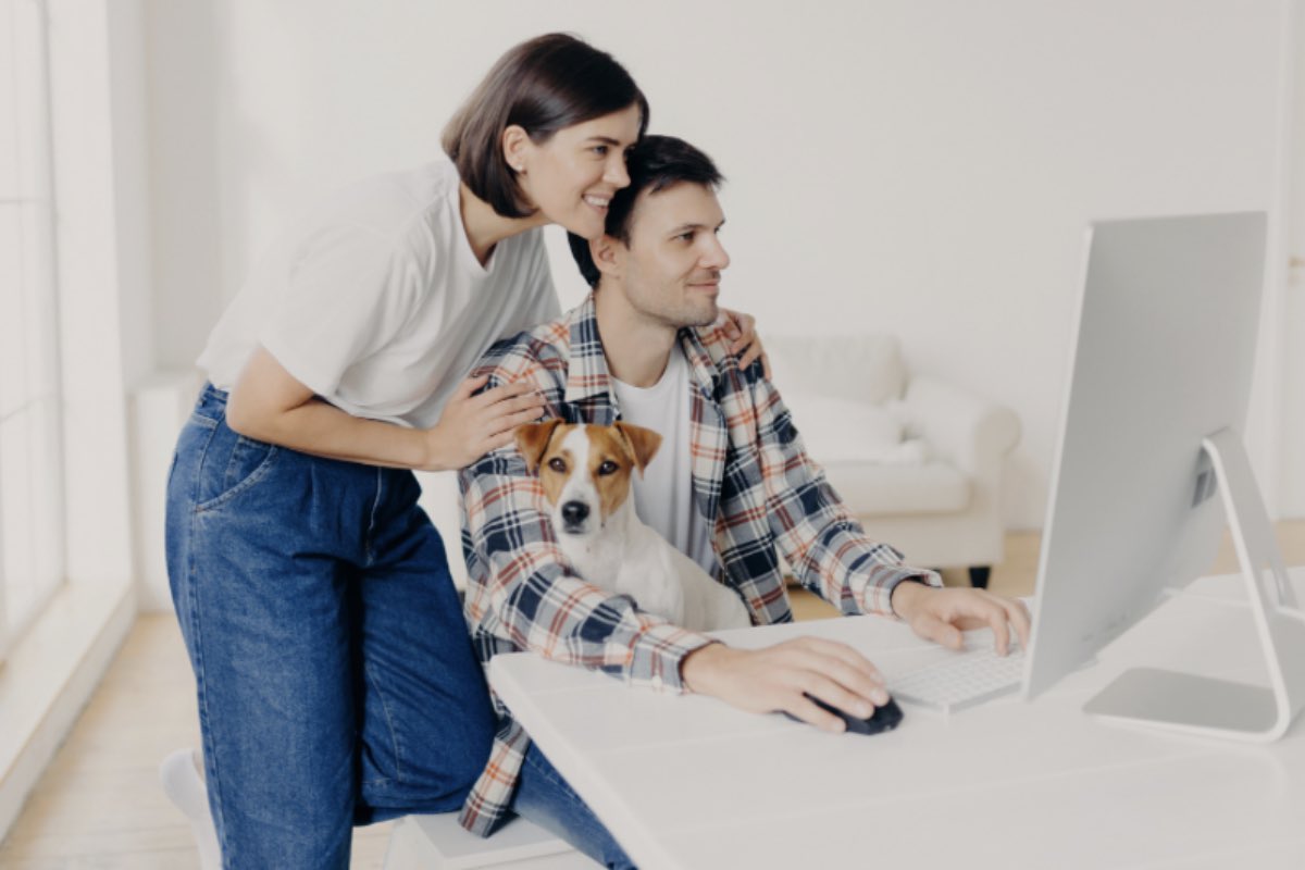 Coppia al computer con cane