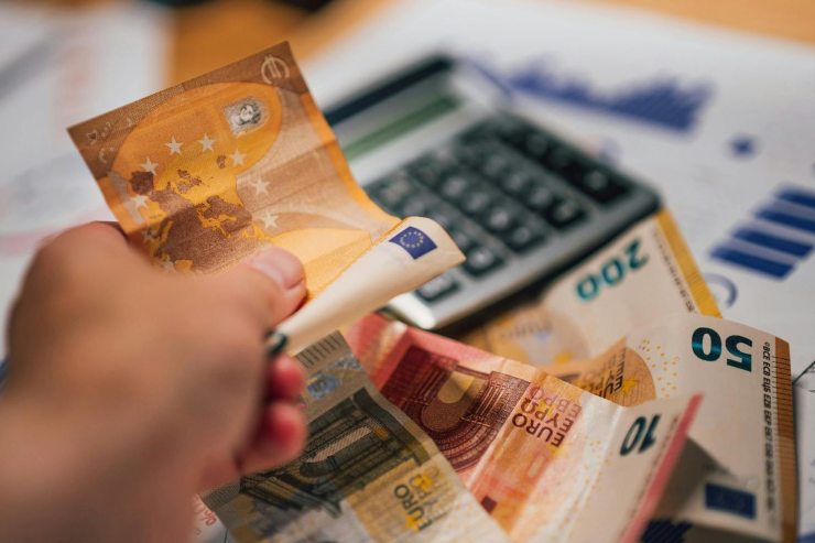 banconote euro in mano e calcolatrice