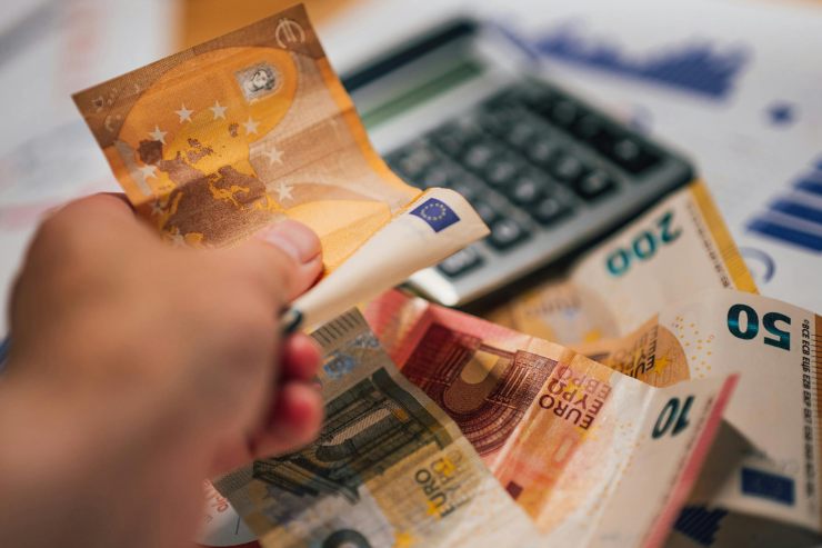 banconote euro in mano e calcolatrice