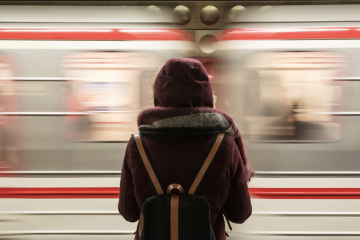 ragazza ferma con treno che corre 