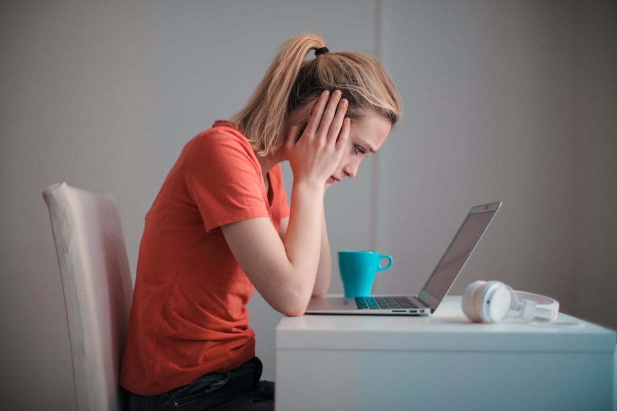 Donna preoccupata che legge al computer