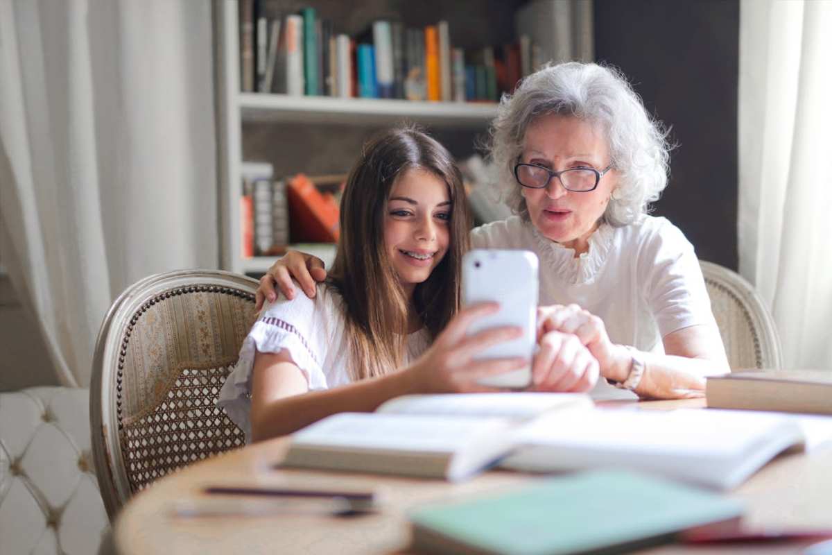 Nonna e nipote che leggono notizie dal cellulare