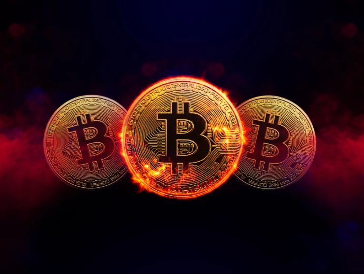 tre monete bitcoin dorate in aria, che bruciano