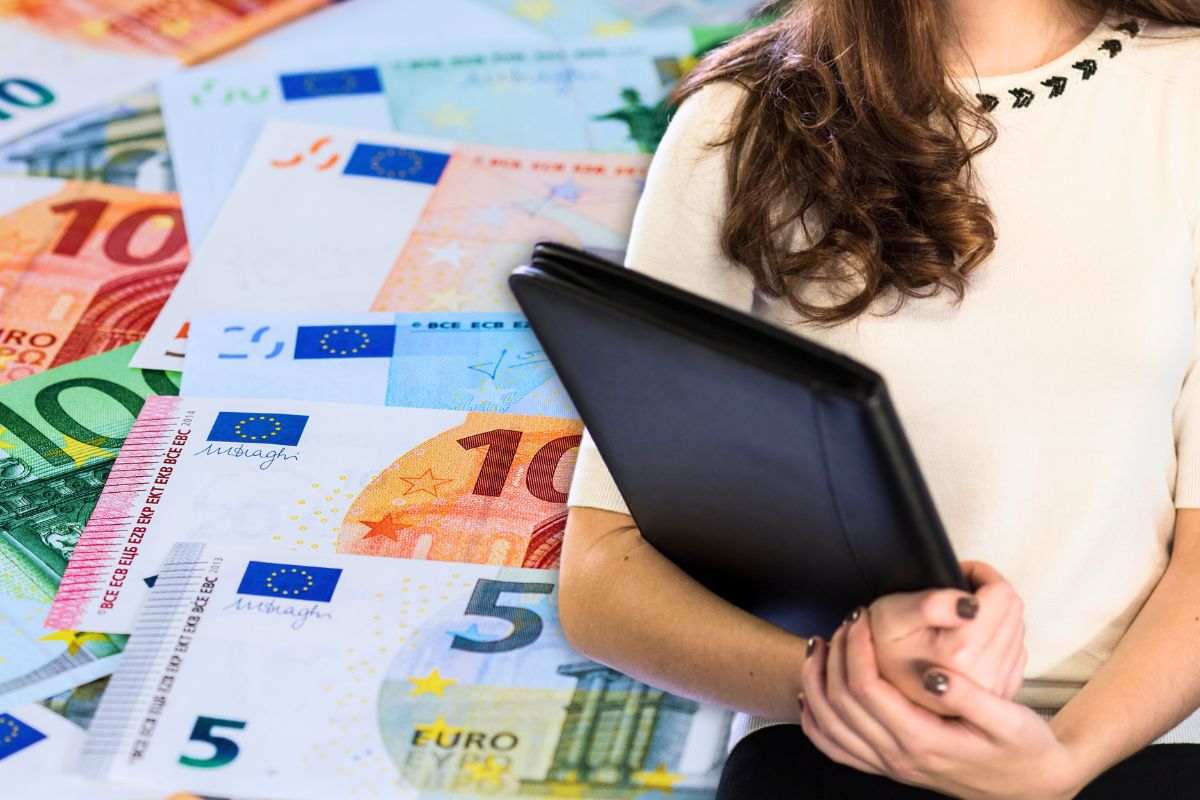 focus lavoratrice e sfondo banconote euro come bonus