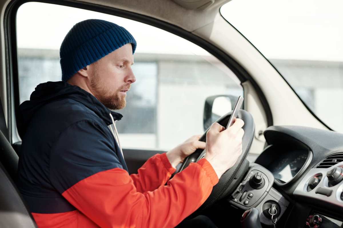 Persona in auto che legge al cellulare