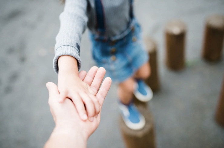 bambino stringe mano al genitore