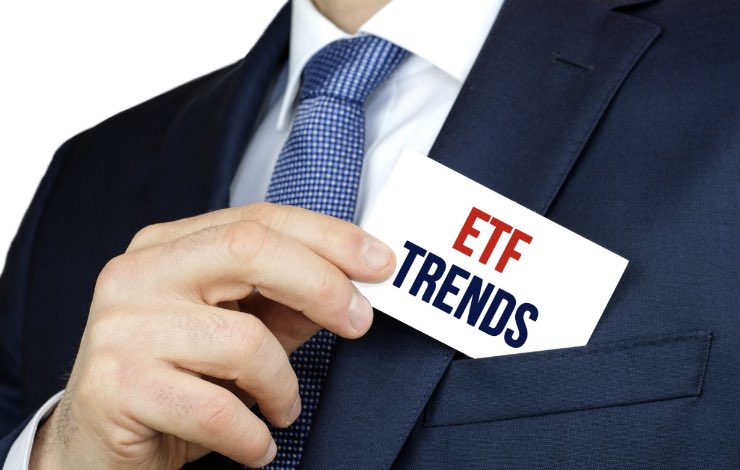 Uomo che tira fuori dal taschino della giacca il biglietto con scritto ETF trends 