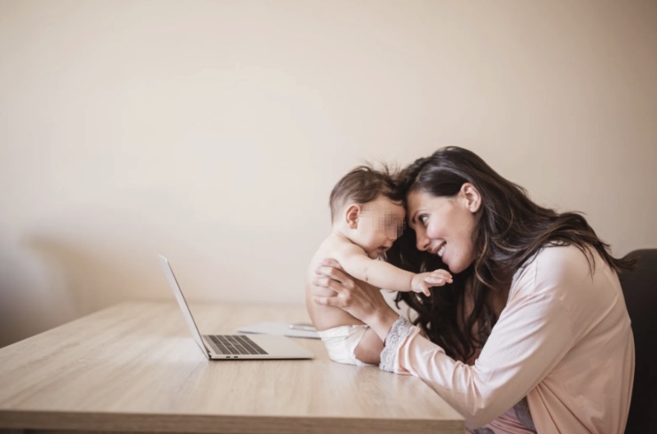 Madre abbraccia suo figlio davanti al computer