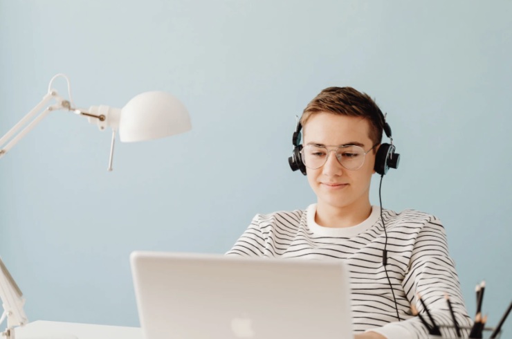 Ragazzo con le cuffie seduto davanti al computer