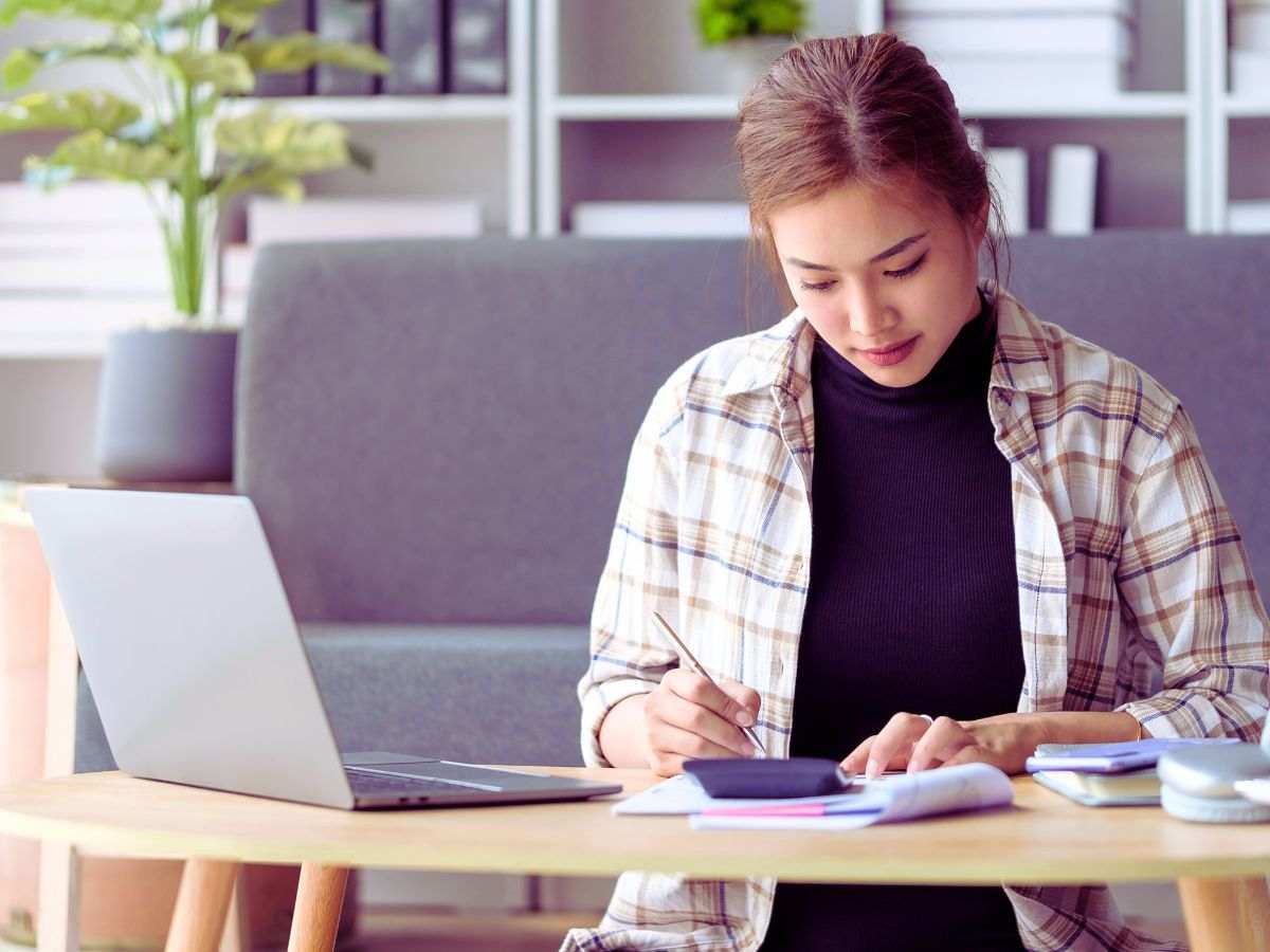 ragazza alla scrivania e pc fa calcoli